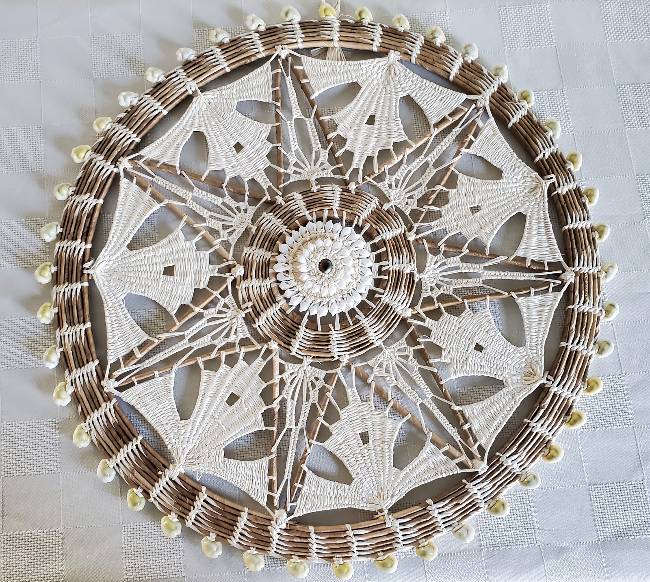 A circular mandala of a star made with shells.